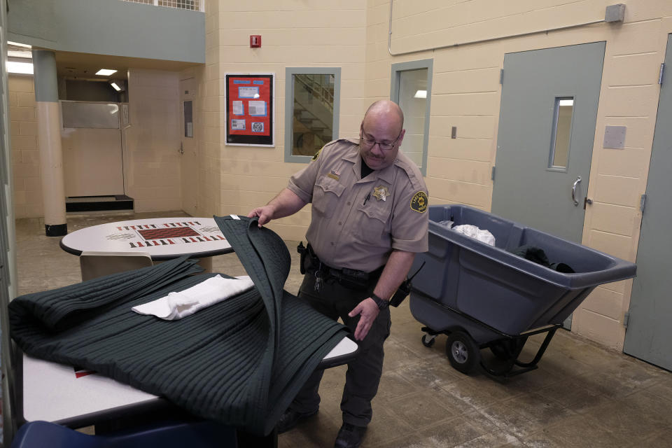 Corrections officer William Tinkler prepares to hand out tear-resistant security blankets at the Lake County Jail in Lakeport , Calif., on Tuesday, April 16, 2019. The blankets were part of a series of changes and reforms made at the jail following the 2015 suicide of Elizabeth Gaunt, who had repeatedly cried for help while locked in a cell. A wrongful death lawsuit resulted in a $2 million settlement. (AP Photo/Eric Risberg)