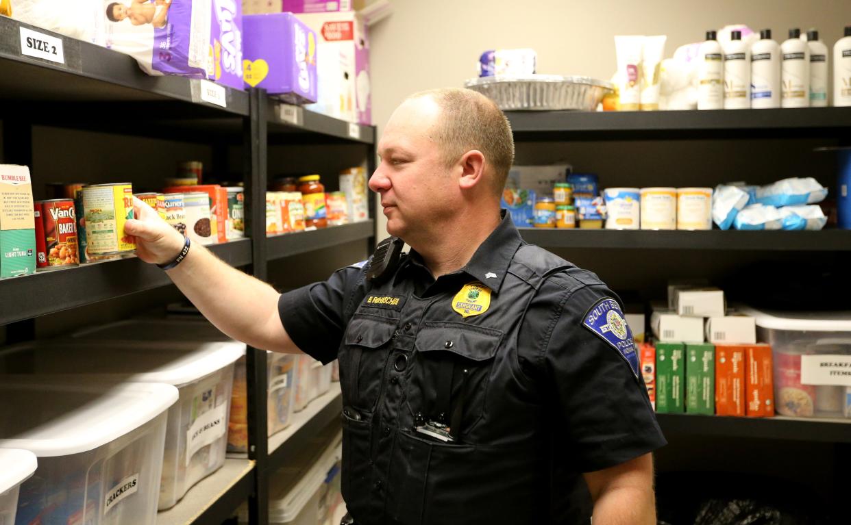 South Bend Police Sgt. Brad Rohrscheib looks over some of the collected items that are stored in an in-house food pantry Tuesday, April 12, 2023, at the South Bend Police Station.