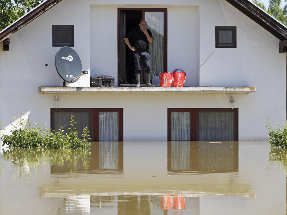 A man waits to be rescued from his house during heavy floods in the village of Vojskova