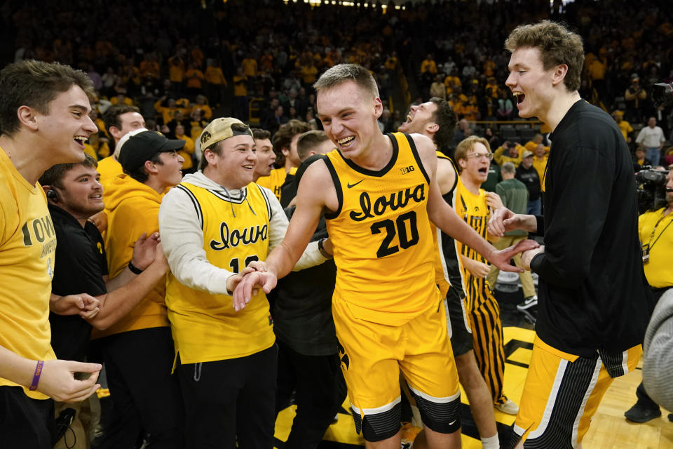 Iowa forward Payton Sandfort (20) celebrates with fans after an NCAA college basketball game against Michigan State, Saturday, Feb. 25, 2023, in Iowa City, Iowa. Iowa won 112-106 in overtime. (AP Photo/Charlie Neibergall)