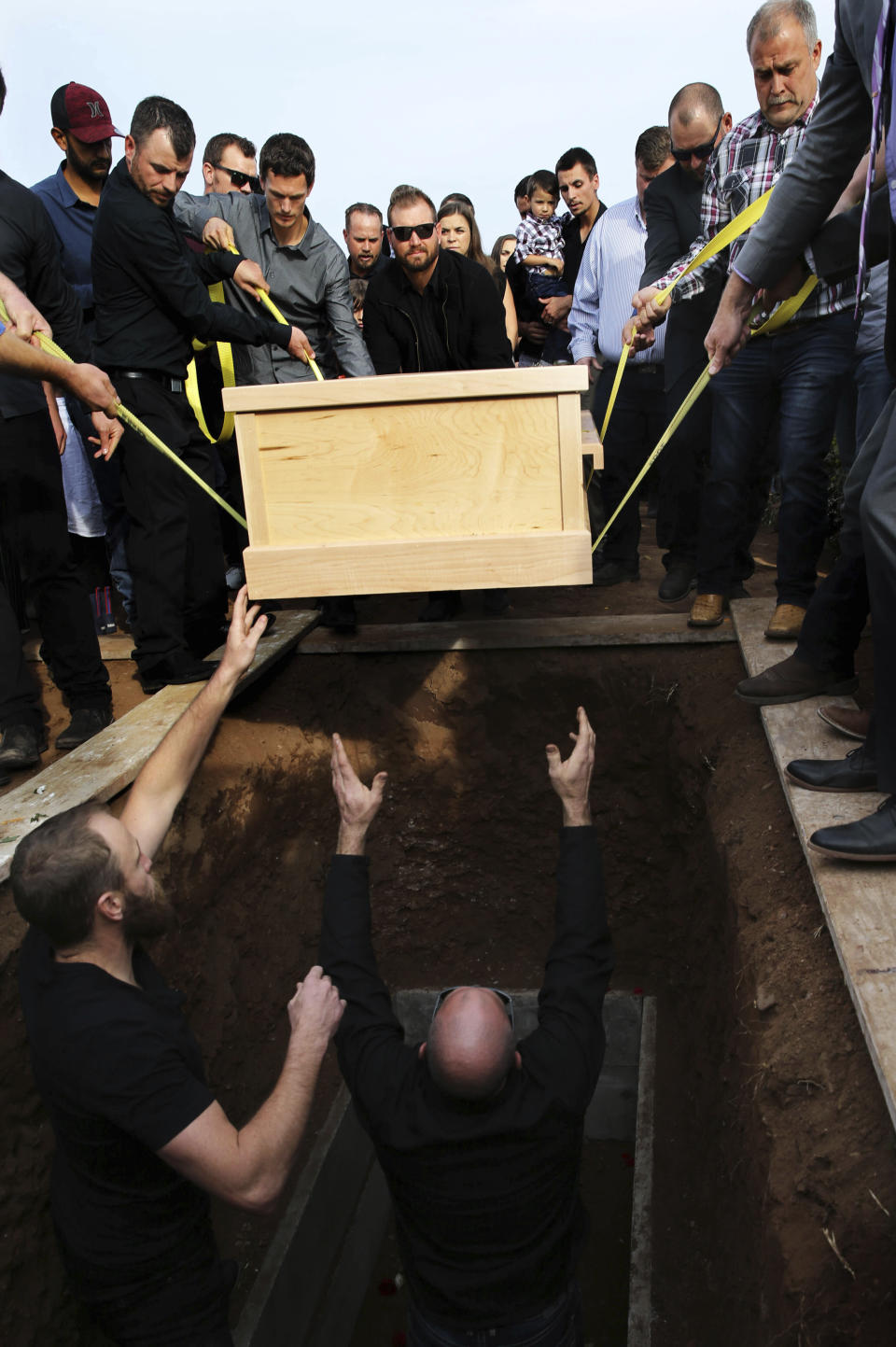 The coffin that contain the remains of Christina Langford Johnson the last victim of a cartel ambush that killed nine American women and children earlier this week, is lowered into a grave in Colonia LeBaron, Mexico, Saturday, Nov. 9, 2019. In the attack Monday, Langford Johnson jumped out of her vehicle and waved her hands to show she was no threat to the attackers and was shot twice in the heart, community members say. Her daughter Faith Marie Johnson, 7 months old, was found unharmed in her car seat. (AP Photo/Marco Ugarte)