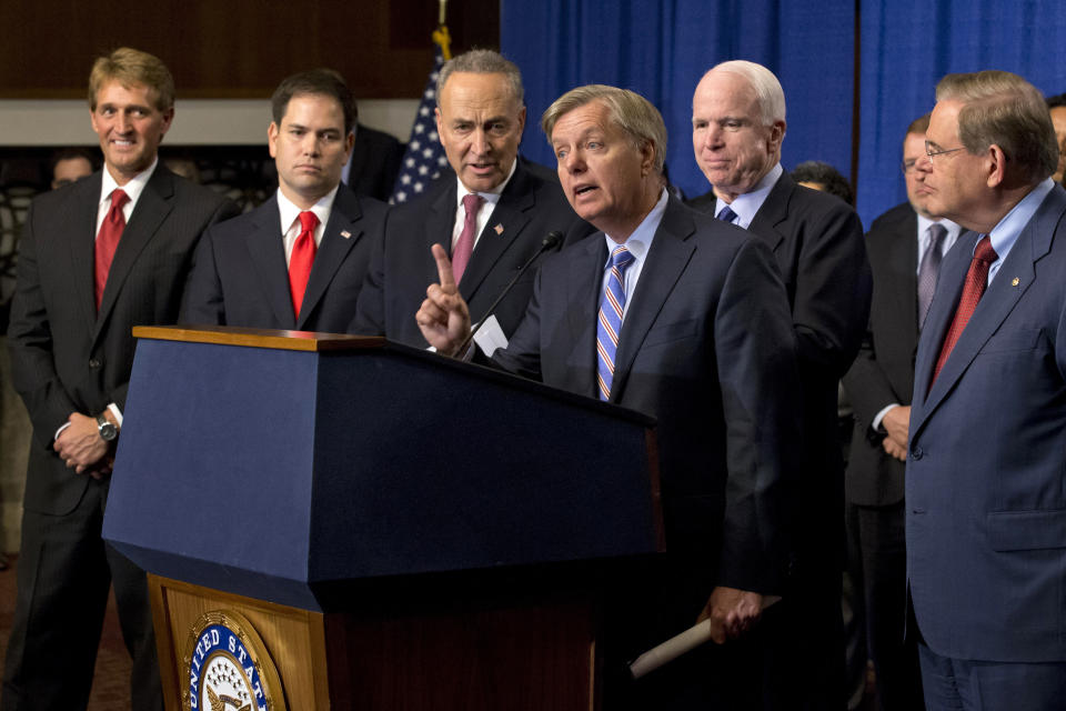 FILE - Sen. Lindsey Graham, R-S.C., center, speaks of immigration reform legislation outlined by the Senate's bipartisan "Gang of Eight" that would create a path for the nation's 11 million unauthorized immigrants to apply for U.S. citizenship, April 18, 2013, on Capitol Hill in Washington. From left are, Sen. Jeff Flake, R-Ariz., Sen. Marco Rubio, R-Fla., Sen. Charles Schumer, Graham, R-S.C., Sen. John McCain, R-Ariz., Sen. Robert Menendez, D-N.J., and Senate Majority Whip Richard Durbin, D-Ill. (AP Photo/J. Scott Applewhite, File)