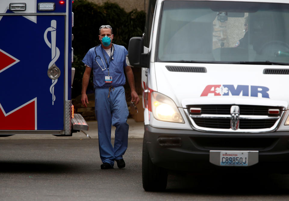 (In this file photo, a doctor walks near an ambulance at the Life Care Center of Kirkland, a long-term care facility linked to several confirmed coronavirus cases, in Kirkland, Washington, U.S. March 5, 2020. (Lindsey Wasson/Reuters/File Photo)