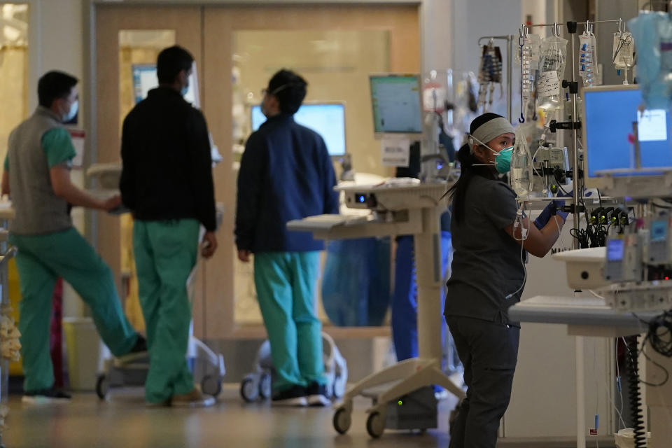 Clinical Nurse Radelle Liban, right, works outside of rooms with COVID-19 patients in the intensive care unit at Santa Clara Valley Medical Center during the coronavirus pandemic in San Jose, Calif., Wednesday, Jan. 13, 2021. (AP Photo/Jeff Chiu)