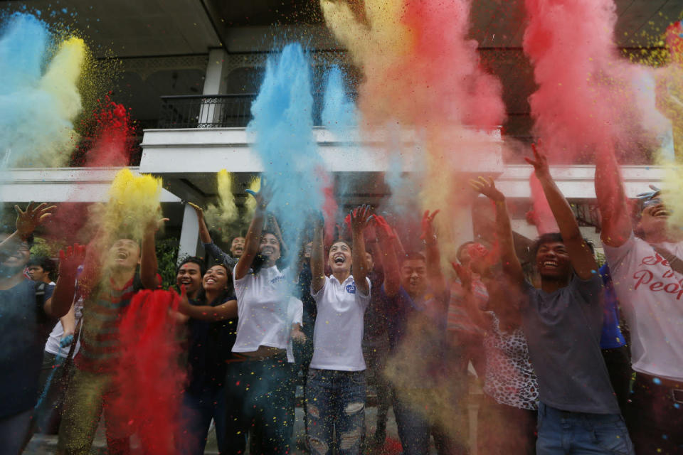 Lovi Poe, center, the sister of presidential candidate Grace Poe, leads the symbolic throwing of colored powder as her sister is endorsed by “Kabataan” party-list group, a youth organization trying to campaign for a seat in the Lower House, May 5, 2016, at suburban Quezon city northeast of Manila, Philippines. Poe is running second to front-running candidate Rodrigo Duterte in recent poll surveys leading to Monday’s Presidential elections. (Bullit Marquez/AP)