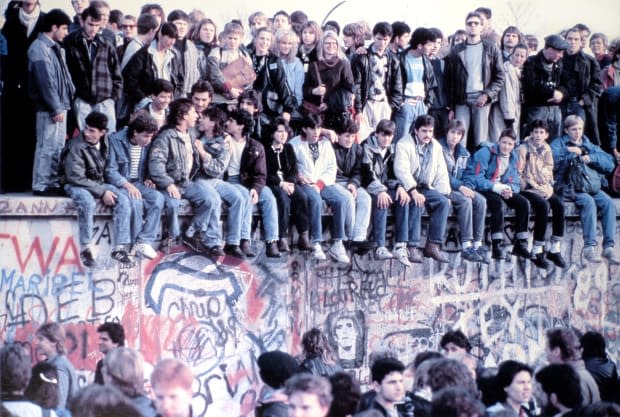 Young people wearing denim — a symbol of Western fashion — on the Berlin Wall in 1989.<p>Photo: Levi Strauss & Co. Archives/Courtesy of Levi's</p>