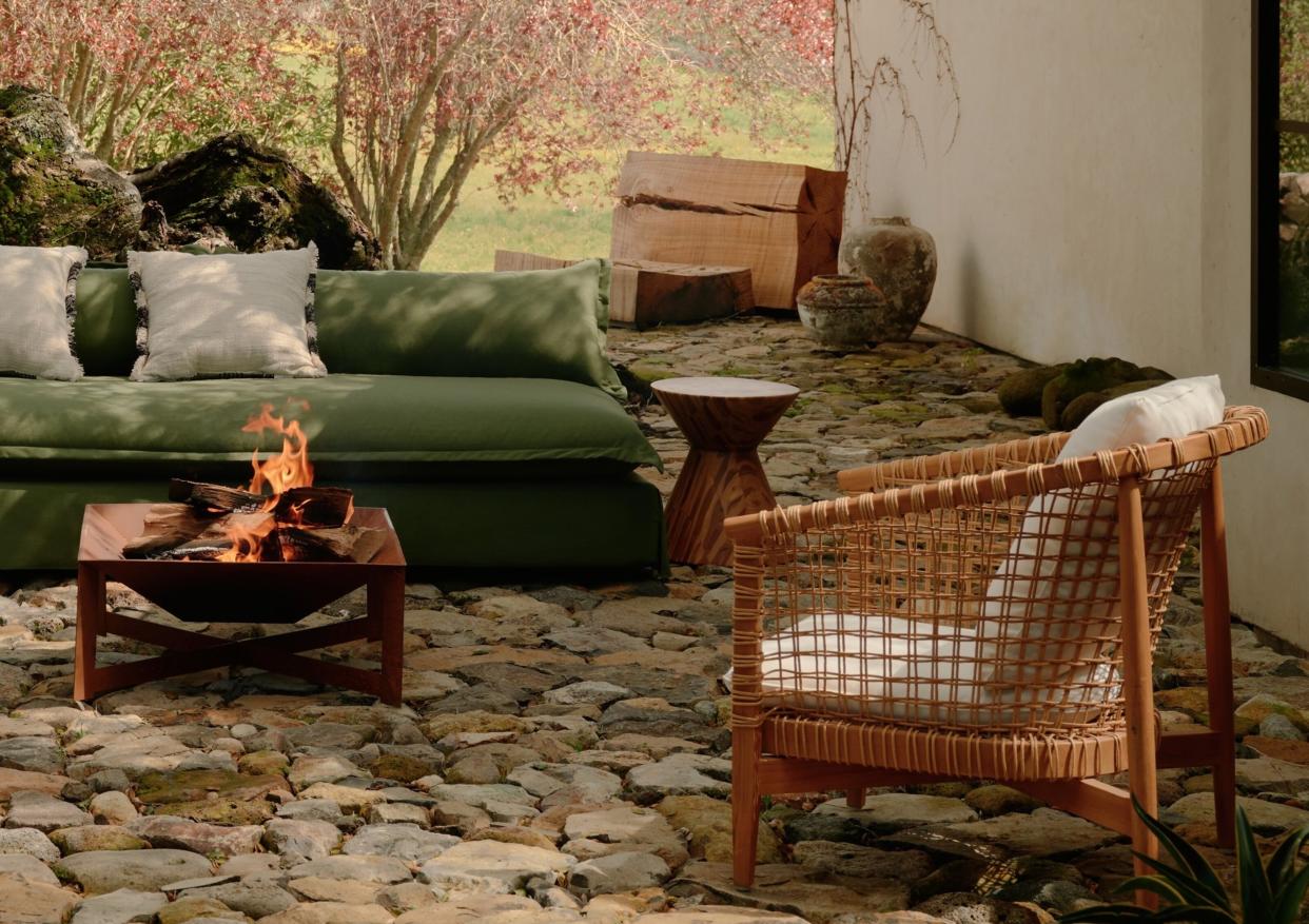  A backyard with a green outdoor sofa and firepit 