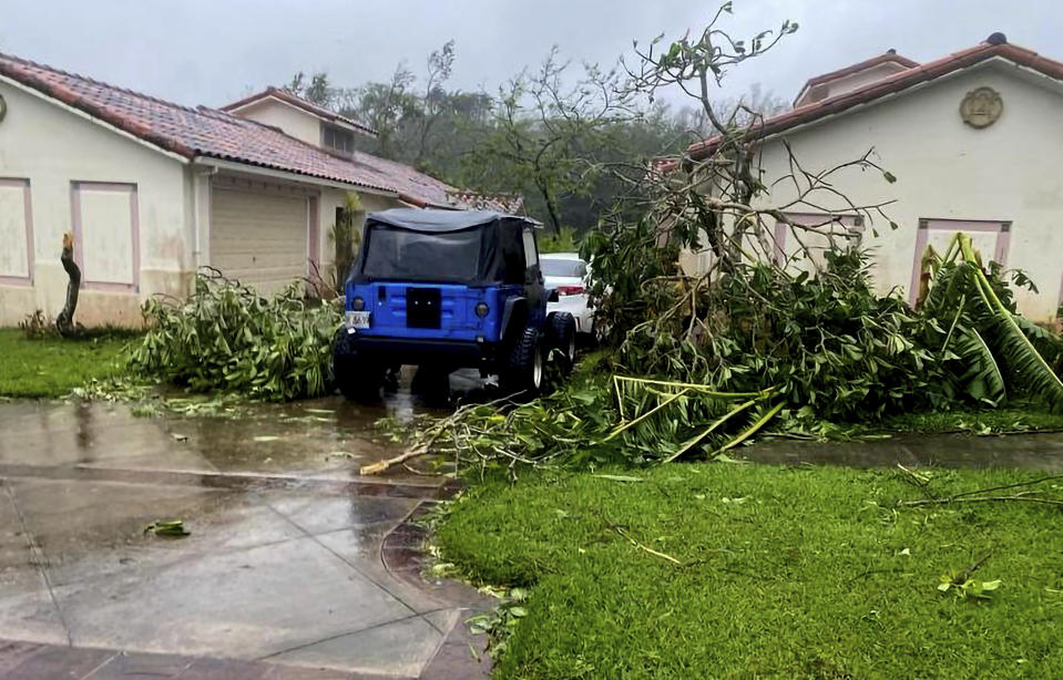 In this photo provided by the U.S. Coast Guard, downed tree branches litter a neighborhood in Yona, Guam, Thursday, May 25, 2023, after Typhoon Mawar passed over the island. The powerful typhoon smashed the U.S. territory of Guam and continued lashing the Pacific island with high winds and heavy rain Thursday, knocking down trees, walls and power lines and creating a powerful storm surge that threatened to wash out low-lying areas. (Chief Warrant Officer Adam Brown/U.S. Coast Guard via AP)