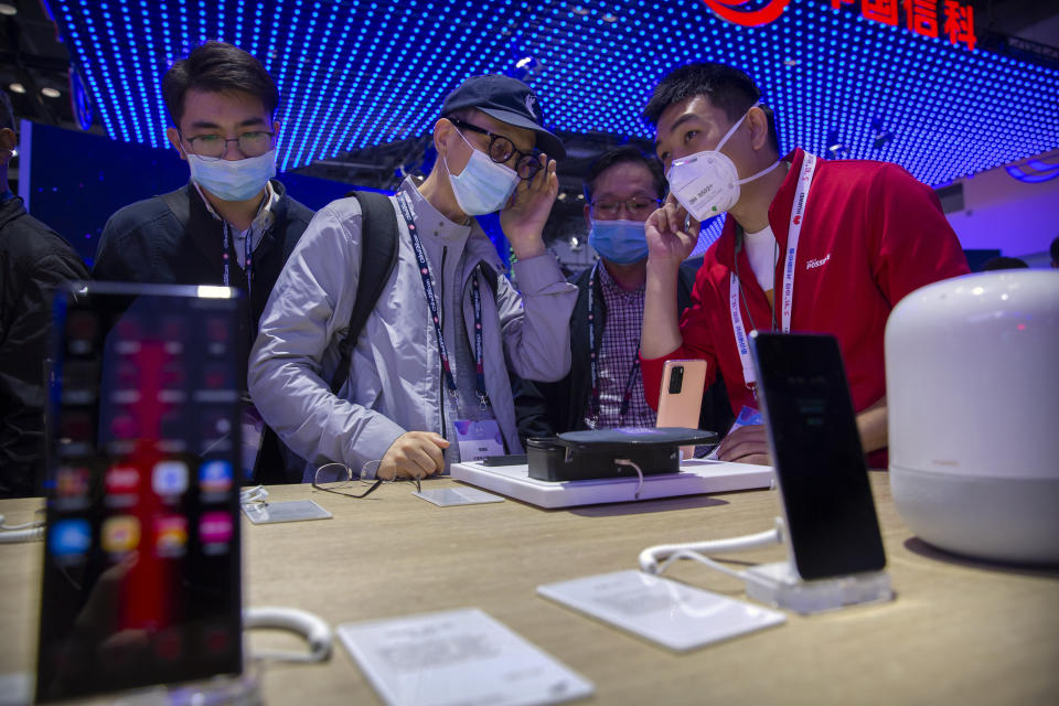 People wearing face masks to protect against the spread of the coronavirus look at smartphones and consumer electronics from Chinese technology firm Huawei at the PT Expo in Beijing, Wednesday, Oct. 14, 2020. Chinese leaders are shifting focus from the coronavirus back to long-term goals of making China a technology leader at this year's highest-profile political event, the meeting of its ceremonial legislature, amid tension with Washington and Europe over trade, Hong Kong and human rights. (AP Photo/Mark Schiefelbein)