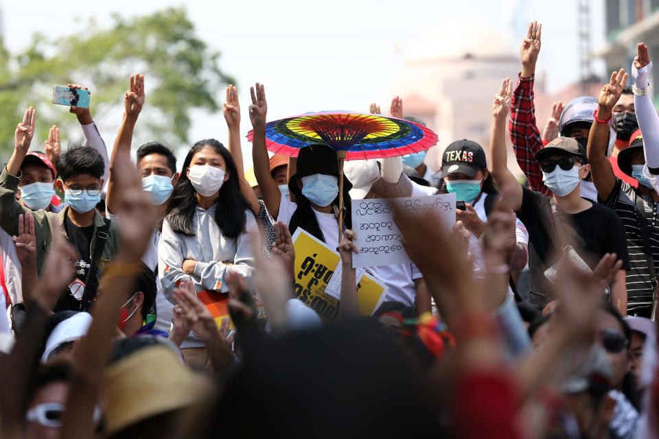 Anti-coup protesters flash the three-fingered salute during a rally in downtown Yangon, Myanmar Friday, Feb. 19, 2021. A young woman who was shot in the head by police during a protest last week against the military's takeover of power in Myanmar died Friday morning, her brother said.(AP Photo)