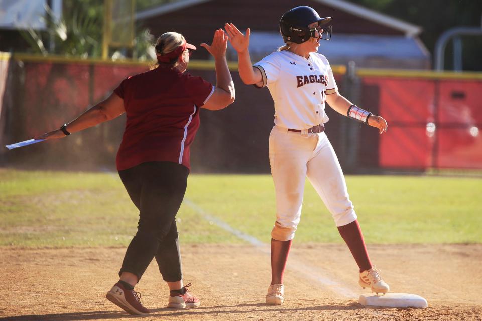 Episcopal's Grace Jones (19) high-fives head coach Kasse Eppley after reacting to making it to third base in a playoff game.