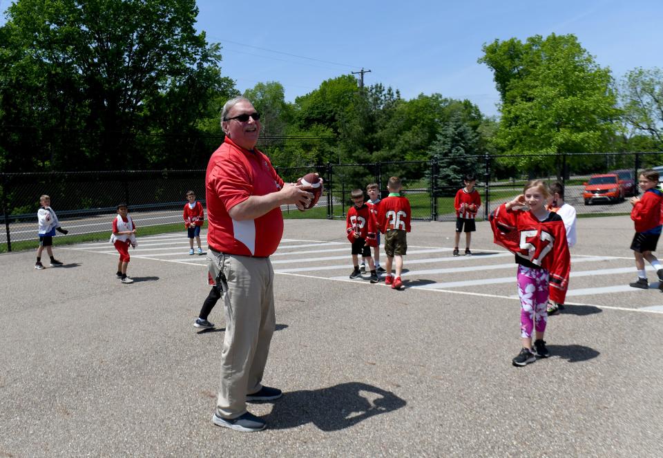 James LaRiccia plays football with second grade students at recess as he prepares to retire after 21 years as Northwest Primary School principal.