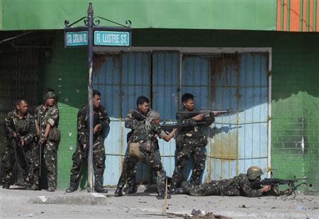Government soldiers fire their weapons during a firefight with Muslim rebels from the Moro National Liberation Front (MNLF) in Zamboanga city in southern Philippines September 12, 2013. REUTERS/Erik De Castro