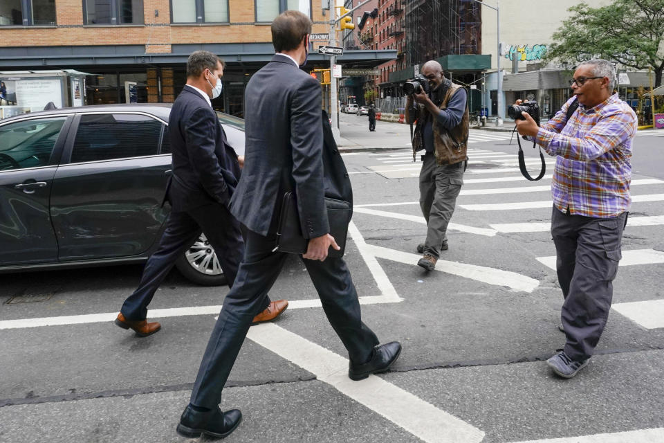 Photographers surround federal agents as they leave the building that houses the Sergeants Benevolent Association offices, Tuesday, Oct. 5, 2021, in New York. Federal agents raided the offices of a New York City police union whose leader has clashed with city officials over his incendiary tweets and hard-line tactics. They also raided the Long Island home of Sergeants Benevolent Association president Ed Mullins. (AP Photo/Mary Altaffer)