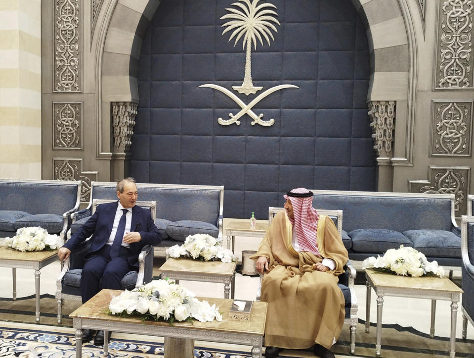 In this photo released by the Syrian official news agency SANA, Saudi Deputy Foreign Minister Waleed Al-Khuraiji, right, meets with Syrian Foreign Minister Faisal Mekdad, upon his arrival at King Abdulaziz International Airport, in Jeddah, Saudi Arabia, Wednesday, April 12, 2023. Syria will reopen its embassy in Tunisia, state media reported Wednesday, as Syria's top diplomat visited Saudi Arabia seeking to restore ties that have been severed for more than a decade. (SANA via AP)