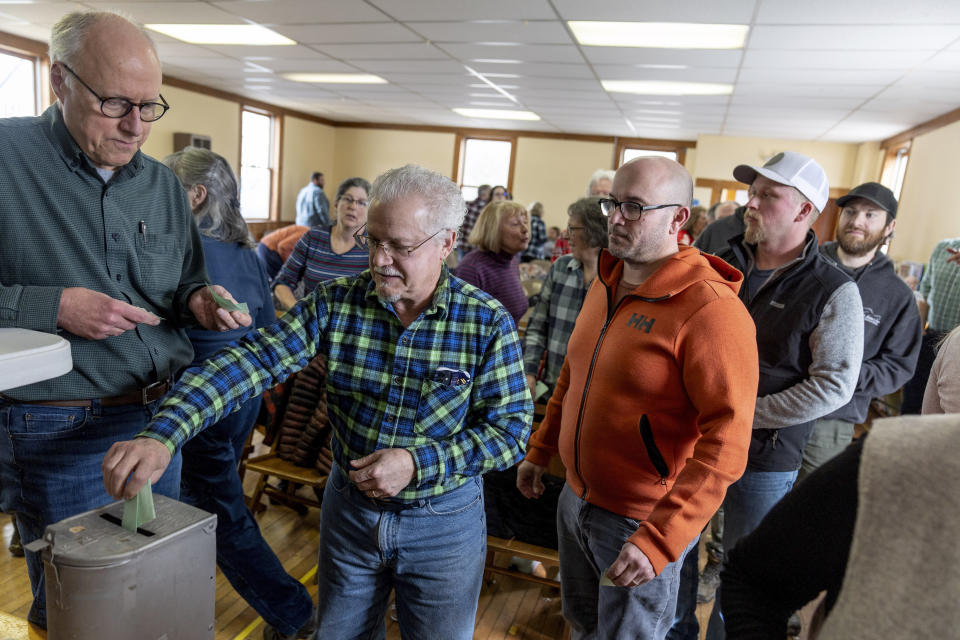 Bruce Olson watches over fellow residents casting their ballots during a vote at the annual Town Meeting, Tuesday, March 5, 2024, in Elmore, Vt. Town meetings give residents a chance to talk, listen, debate and vote. Many people who attend town meetings say the tone is refreshingly civil when compared with the nastiness of national politics because people are debating issues with their neighbors face-to-face. (AP Photo/David Goldman)