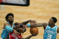 Portland Trail Blazers forward Rondae Hollis-Jefferson drives to the basket between Charlotte Hornets forward Jalen McDaniels and guard Terry Rozier (3) during the first half in an NBA basketball game on Sunday, April 18, 2021, in Charlotte, N.C. (AP Photo/Chris Carlson)
