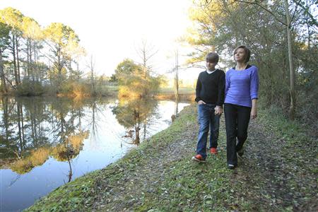 Kelly Muscolino, whose husband Mike is a prisoner serving 20 years for armed robbery, walks with their son Devin, 13, near their home in Philadelphia, Mississippi January 15, 2014. REUTERS/Thomas Wells