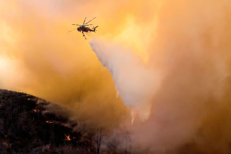 FILE PHOTO: A helicopter makes a water drop over a wildfire in the Angeles National Forest during the Bobcat Fire in Los Angeles