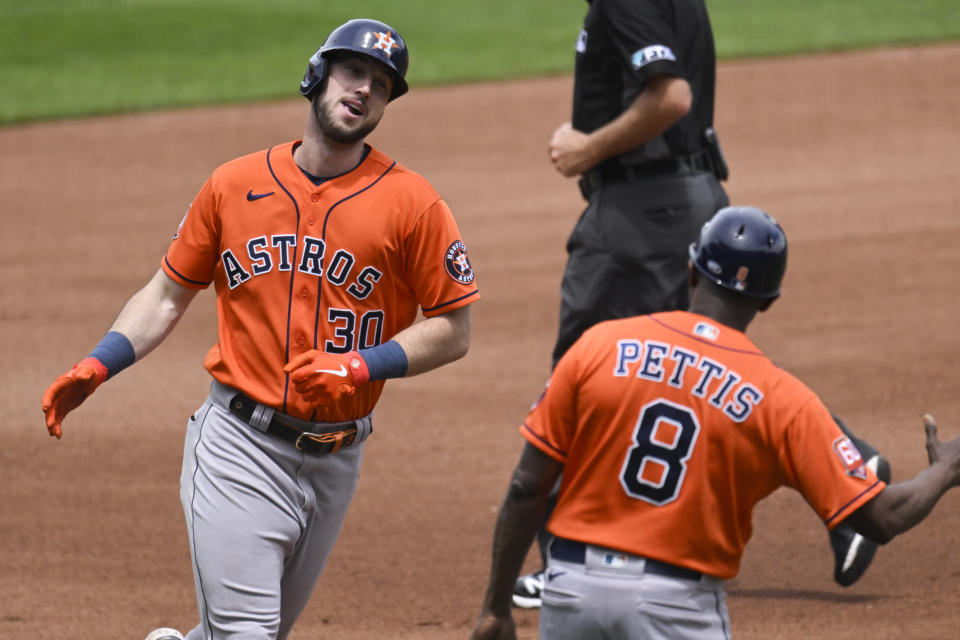 The Houston Astros' Kyle Tucker (30) is congratulated by third base coach Gary Pettis (8) as he heads home after hitting a home run during the fourth inning of a baseball game against the Kansas City Royals, Sunday, June 5, 2022, in Kansas City, Mo. (AP Photo/Reed Hoffmann)
