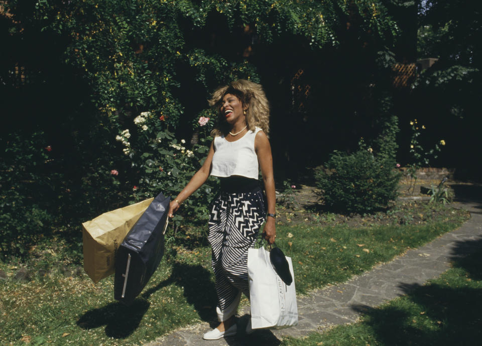 Tina walking outside while carrying shopping bags