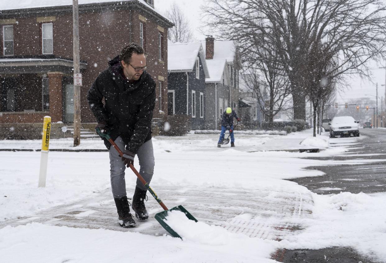 Ben George shovels his sidewalk on Thuman Ave. as the snow falls in Columbus, Ohio, on Sunday, Jan. 23, 2022. George and his family back to Columbus from Florida in November so that they could be closer to family.