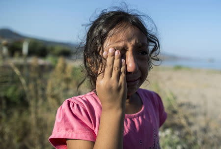 Yasmine, a 6-year-old migrant from Deir Al Zour in war-torn Syria, cries on the beach after arriving on the Greek island of Lesbos in this September 11, 2015 file photo. REUTERS/Zohra Bensemra/Files