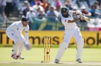 South Africa's Hashim Amla plays a shot as England's Jonny Bairstow looks on during the second cricket test match in Cape Town, South Africa, January 3, 2016. REUTERS/Mike Hutchings