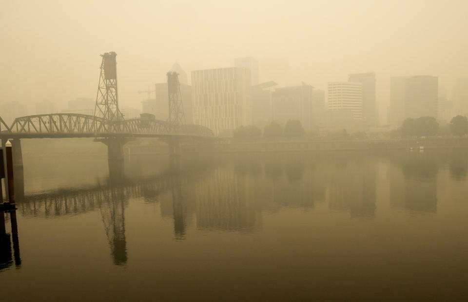 In this photo provided by Don Ryan, heavy smoke from wildfires envelops the Willamette Bridge and downtown Portland, Ore., Wednesday, Sept. 16, 2020. Dangerously dirty air spewing from the West Coast wildfires is seeping into homes and businesses, sneaking into cars through air conditioning vents and preventing people already shut away by the coronavirus pandemic from enjoying a walk or trip to the park. (Don Ryan via AP)