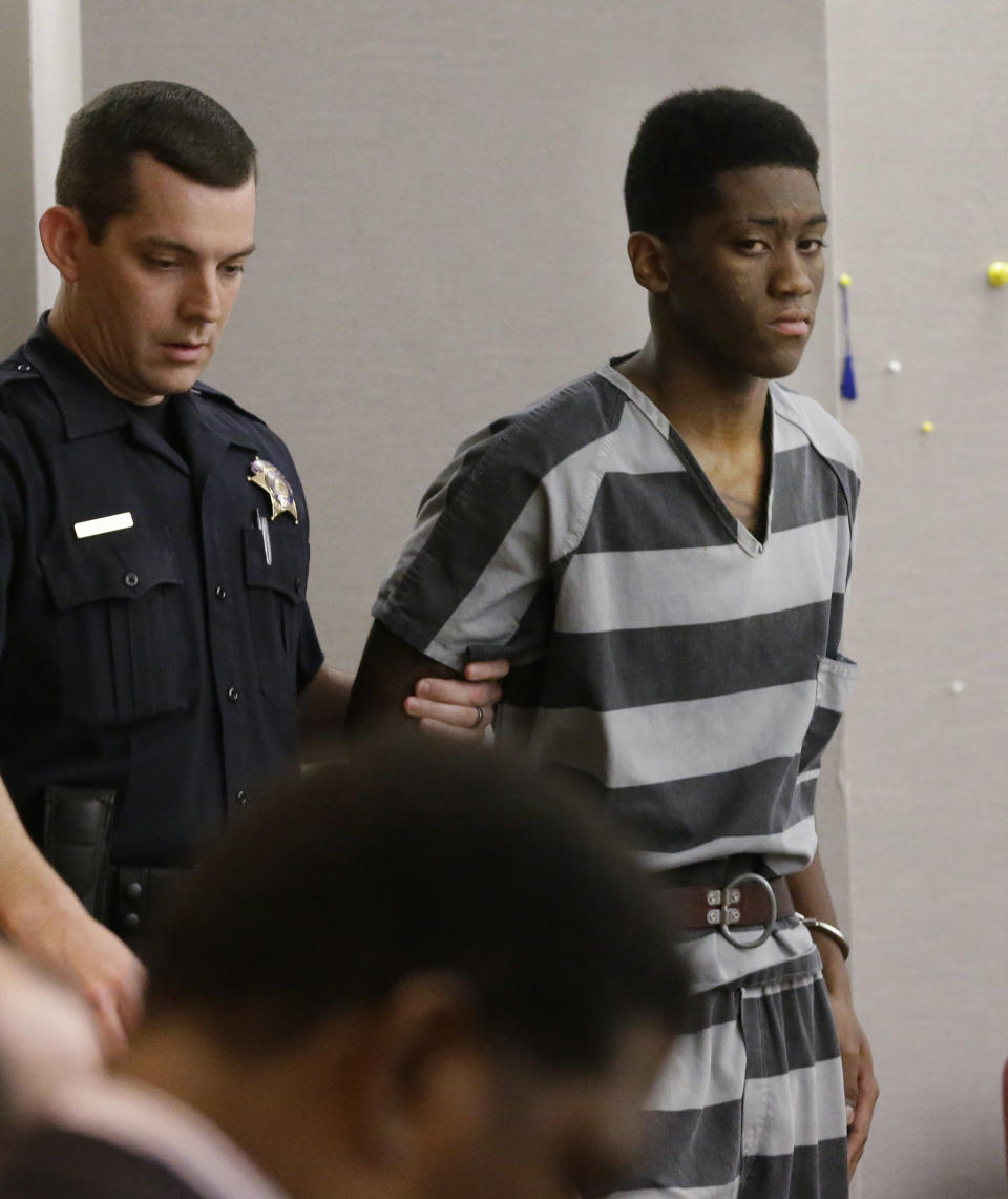 Sir Young, 20, is led into court before a hearing in Dallas Thursday, May 8, 2014. A district court judge has reversed a previous order and imposed a series of probationary requirements for the 20-year-old man convicted of raping a schoolmate. The initial punishment for Young sparked a backlash when a prior judge in Dallas sentenced him to five years of probation and declined to impose standard conditions of probation for sex offenders. (AP Photo/LM Otero)