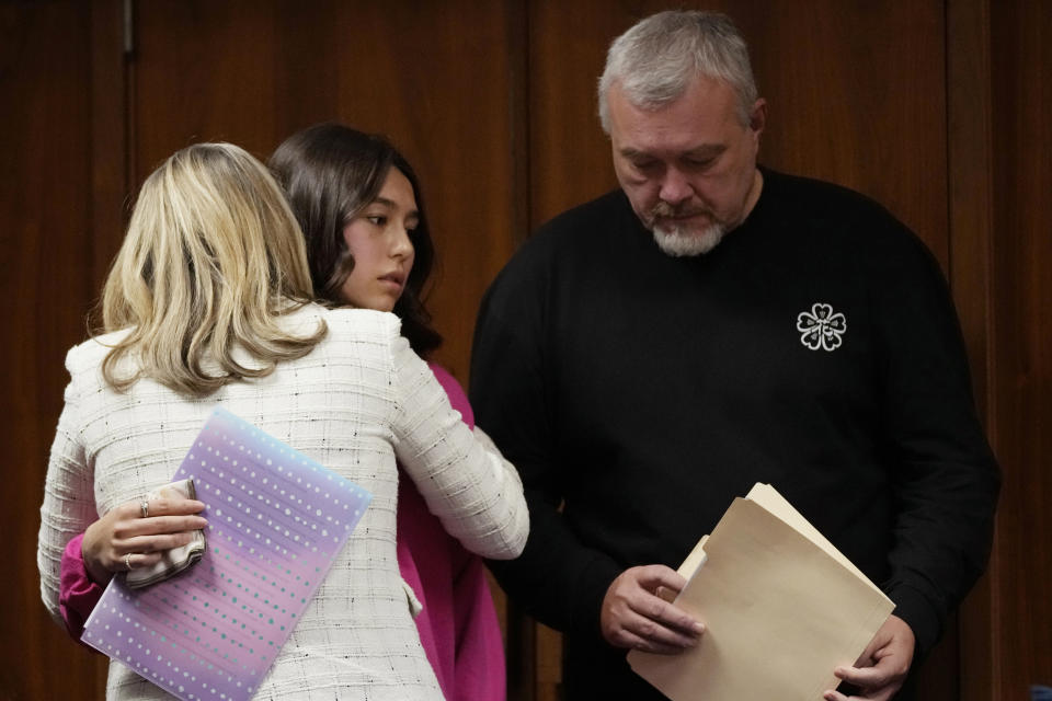 Reina St. Juliana, sister of victim Hana St. Juliana, stands next to her father Steve and is hugged by prosecutor Karen McDonald after giving her impact statement, Friday, Dec. 8, 2023, in Pontiac, Mich. Parents of students killed at Michigan's Oxford High School described the anguish of losing their children Friday as a judge considered whether a teenager will serve a life sentence for a mass shooting in 2021. Ethan Crumbley, 17, could be locked up with no chance for parole for killing four fellow students and wounding others.(AP Photo/Carlos Osorio, Pool)