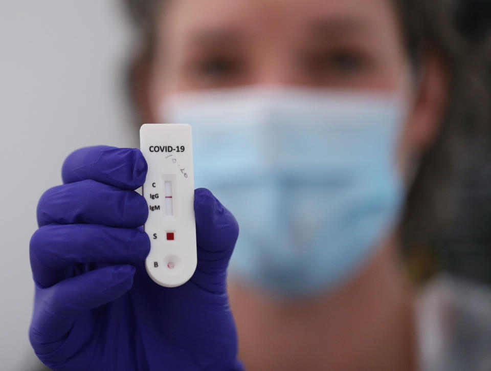 Katy Peters, of the London Vaccination Clinic, holding a client's positive result for a rapid antibody fingertip test for the detection of COVID-19, in Notting Hill, London, as the UK continues in lockdown to help curb the spread of the coronavirus.