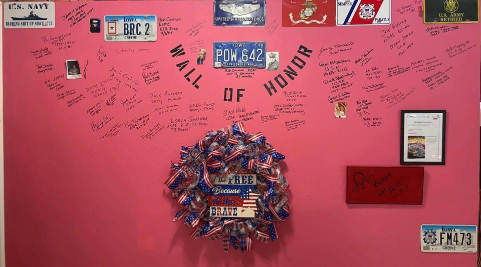 The first thing you see at the Junkyard Cafe in Jefferson is the Wall of Honor on a hot pink wall.