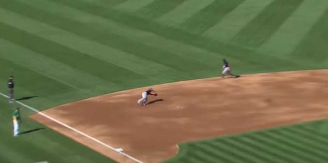 Baseball player dives for incoming baseball