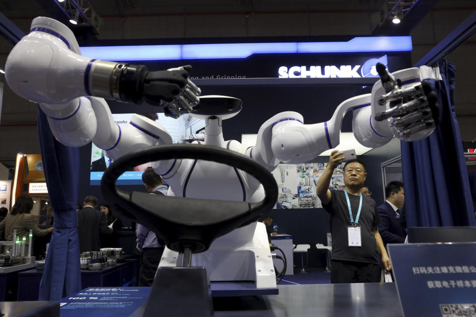 In this Wednesday, Nov. 6, 2019, file photo, a visitor takes a photo of a robot that can be used to operate a vehicle during the China International Import Expo in Shanghai. The sprawling import fair into its second year is meant to demonstrate China's willingness to open its domestic markets.(AP Photo/Ng Han Guan, File)