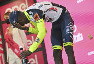 Eritrea's Biniam Girmay touches his eye after spraying sparkling wine on the podium to celebrate winning the 10th stage of the Giro D'Italia cycling race from Pescara to Jesi, Italy, Tuesday, May 17, 2022. Girmay was then taken to a local hospital after getting injured when he popped a champagne cork into his eye during the podium celebration. (Massimo Paolone/LaPresse via AP)