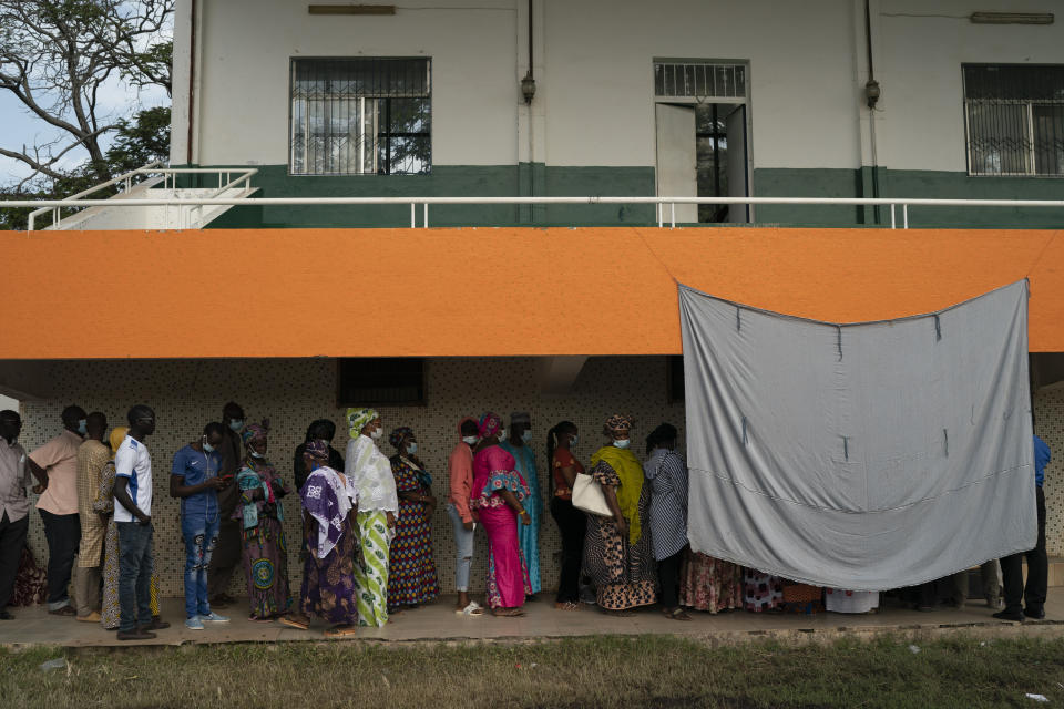 People line up to cast their ballot for Gambia's presidential elections, in Banjul, Gambia, Saturday, Dec. 4, 2021. Lines of voters formed outside polling stations in Gambia’s capital as the nation holds a presidential election. The election on Saturday is the first in decades without former dictator Yahya Jammeh as a candidate. (AP Photo/Leo Correa)