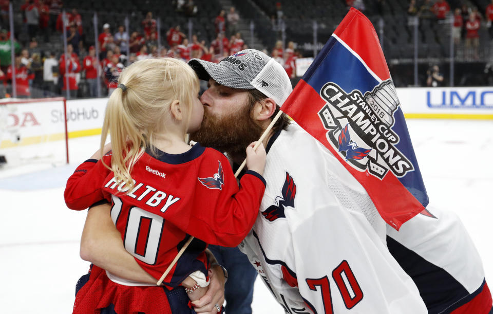 FILE - In this June 7, 2018, file photo, Washington Capitals goaltender Braden Holtby, right, kisses his daughter Belle after the Capitals defeated the Vegas Golden Knights 4-3 in Game 5 of the NHL hockey Stanley Cup Finals in Las Vegas. The past few weeks have seen several recent Stanley Cup winners get rid of members of their championship core. The Chicago Blackhawks moved on from Corey Crawford, the Washington Capitals did the same with Braden Holtby, the Pittsburgh Penguins traded fellow goalie Matt Murray and forward Patric Hornqvist and the St. Louis Blues signing Torey Krug means captain Alex Pietrangelo will sign elsewhere. (AP Photo/John Locher, File)