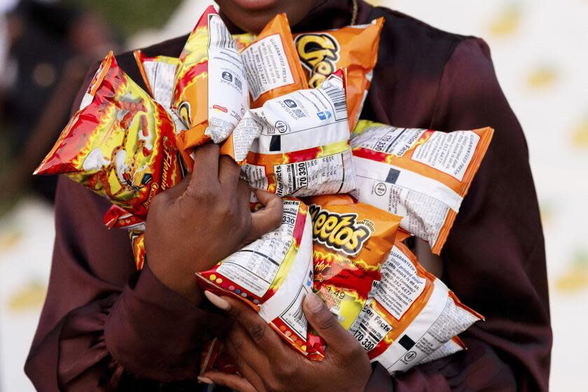 A White House press assistant carries bags of Flamin' Hot Cheetos prior to a screening of "Flamin' Hot" on the South Lawn of the White House on June 15, 2023 in Washington, D.C. (Photo by Julia Nikhinson/Sipa USA)(Sipa via AP Images)