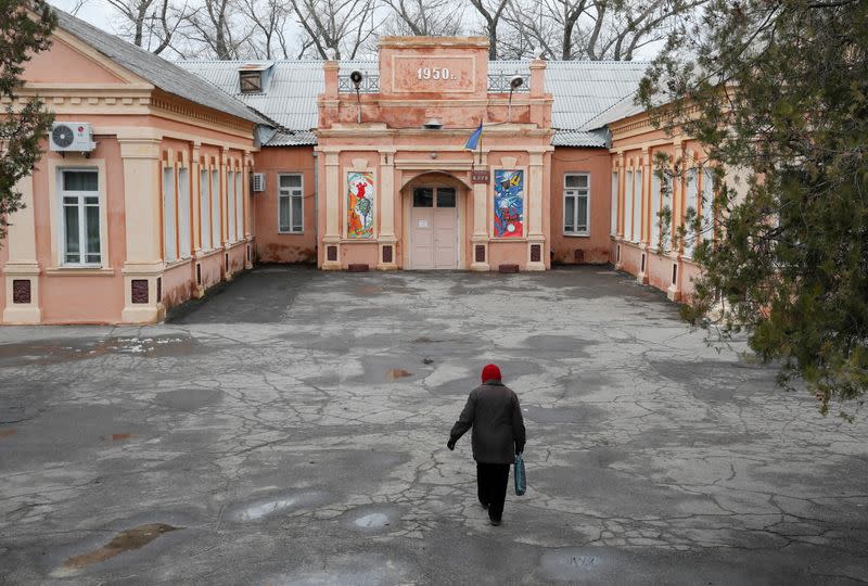 A woman approaches a building in the town of Novhorodske