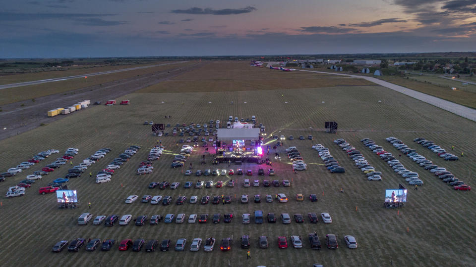 Fans attend the drive-in concert of the Hungarian rock band Tankcsapda at the Debrecen International Airport in Debrecen, Hungary, Friday, May 29, 2020, when concert halls are still closed in Hungary due to the pandemic of the novel coronavirus COVID-19. (Zsolt Czegledi/MTI via AP)