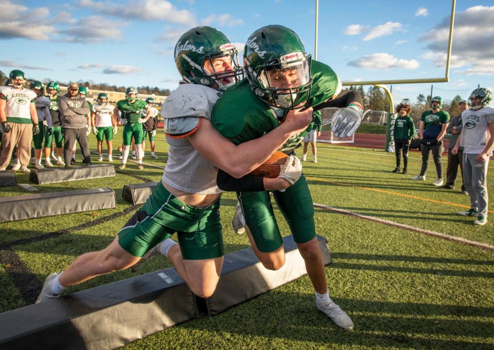 Grafton's Riley McCann, left, wraps up teammate James Hanna during a practice drill last season for the Gators.