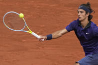 Italy's Lorenzo Musetti plays a return to Serbia's Novak Djokovic during their fourth round match on day 9, of the French Open tennis tournament at Roland Garros in Paris, France, Monday, June 7, 2021. (AP Photo/Michel Euler)