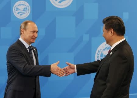 Russia's President Vladimir Putin (L) greets Chinese President Xi Jinping during the Shanghai Cooperation Organization (SCO) summit in Ufa, Russia, July 10, 2015. REUTERS/Sergei Karpukhin