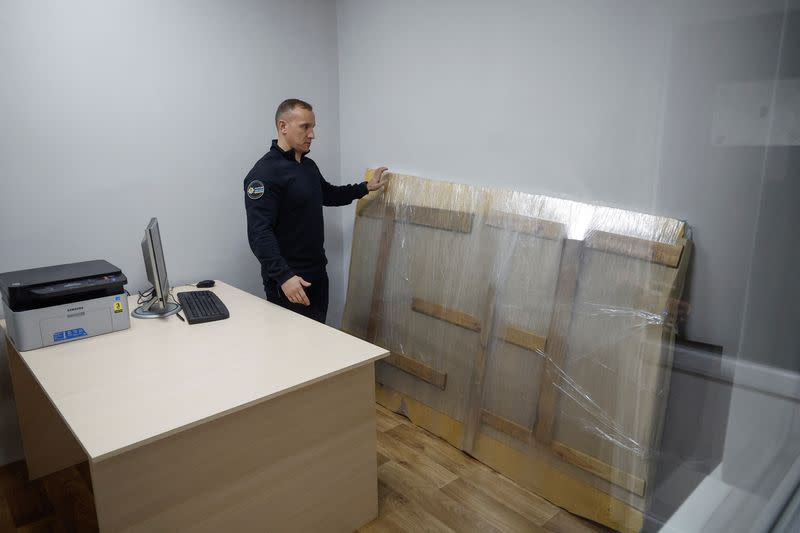 Chief of Kyiv regional police Nebytov stands next to the work of street artist Banksy which a group of people tried to steal from a wall of a residential building in Hostomel, at a police office in Boiarka