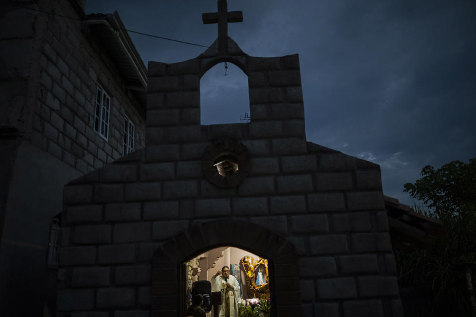 Friar Leopoldo Serrano celebrates Mass, broadcast via Facebook, at a chapel in Mission San Francisco de Asis, Honduras, late Saturday, June 19, 2021. Located on the border of the departments of Santa Barbara and Copan, his sprawling mission straddles the road that is one of the region's main drug trafficking corridors. (AP Photo/Rodrigo Abd)