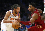 New York Knicks guard Jalen Brunson, left, dribbles around Cleveland Cavaliers guard Donovan Mitchell during the second half of an NBA basketball game Sunday, Dec. 4, 2022, in New York. The Knicks won 92-81. (AP Photo/John Munson)