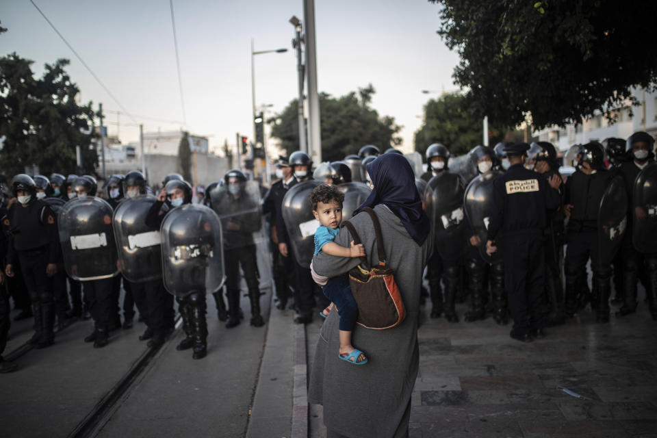 Security forces stand guard as they prepare to disperse a protest against the government enforcing of a mandatory COVID-19 vaccine pass, in Rabat, Morocco, Sunday, Oct. 31, 2021. (AP Photo/Mosa'ab Elshamy)