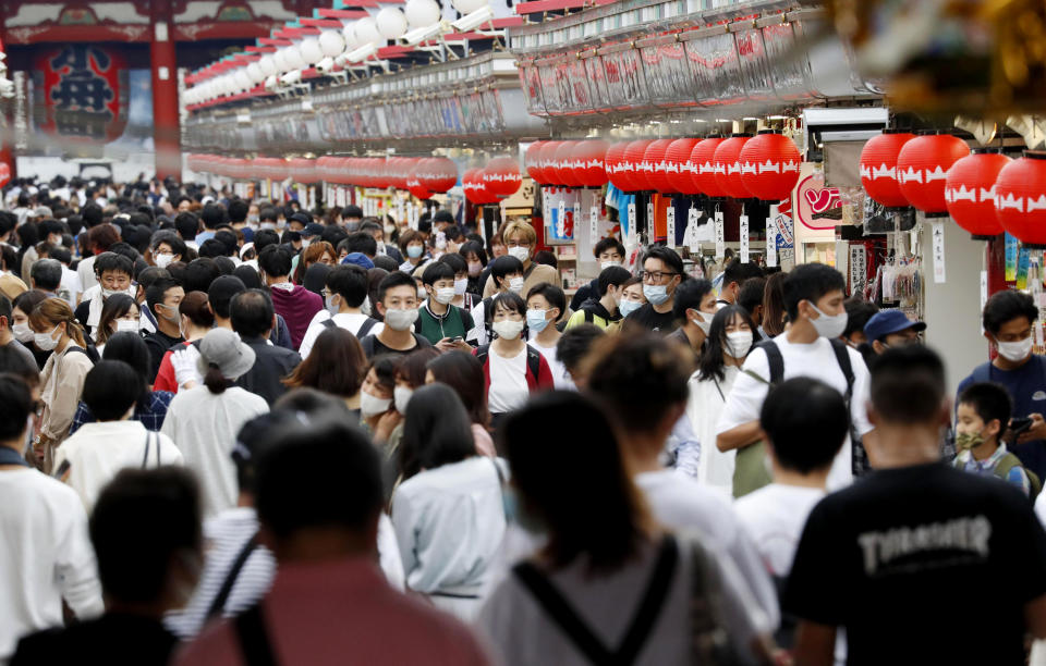 People wearing face masks pack in a shopping arcade of Asakusa district in Tokyo Sunday, Sept. 20, 2020. Train stations and airports in Japan are filled with people traveling over the “Silver Week” holiday weekend, in a sign of recovery amid the coronavirus pandemic. (Kyodo News via AP)