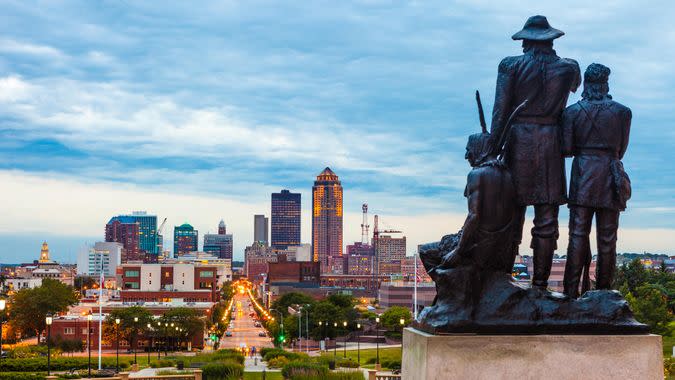 Downtown Des Moines, Iowa with the Pioneers of the Territory statue in the foreground.